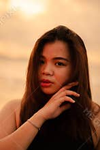 a beautiful and sexy Asian woman with flat facial expressions and posing with his hand under his chin