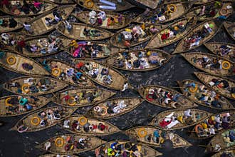 Boats filled with travelers crossing the river to their workplace