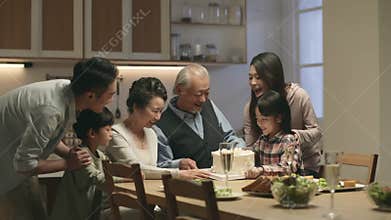 asian family celebrating wedding anniversary of senior couple