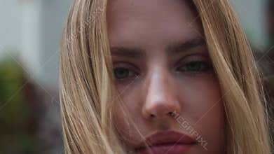 Close up portrait of Young Woman smiling with blonde hair blowing in wind outdoor at urban city Slow Motion