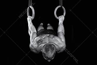 Strong gymnast works on the rings