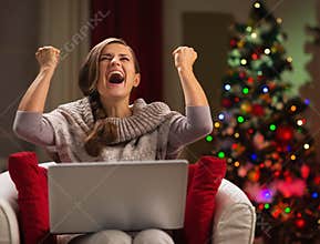 Happy woman with laptop rejoicing success