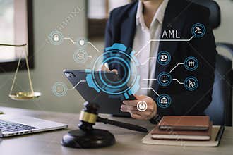 Judge in a courtroom using laptop and tablet with AML anti money laundering icon on virtual screen