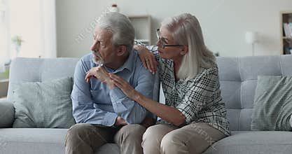 Loving senior wife calming, comforts and encourages frustrated husband