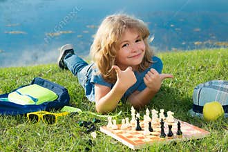 Little child play chess. Kid playing board game. Thinking child brainstorming and idea in chess game. Chess school and