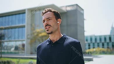 Business man putting earbuds walking sunny street close up. Boss calling phone