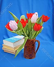 Books and jug of tulips