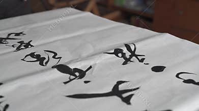 An old calligrapher is creating and writing Chinese calligraphy works.