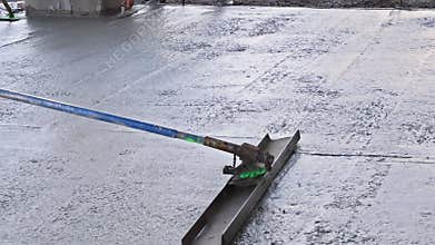 In construction site, workers are leveling concrete for driveway with a readymix concrete trowel in slump concrete
