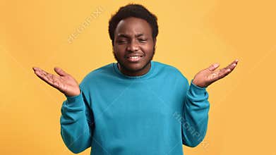 Portrait funny African man with doubt face expression don't know confused posing isolated on orange