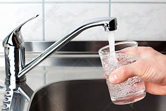 Glass filled with drinking water from kitchen faucet.