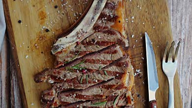 T bone beef steak grill sliced on a board. Top view. Close up.