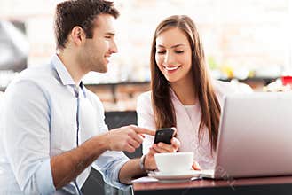 Business people using laptop at cafe