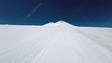 Freshly prepared piste at the ski resort of the snow-capped Mount Elbrus. Aerial view from quadcopter fpv