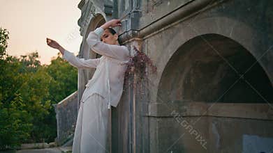 Gorgeous model posing ancient building leaning old wall. Woman posturing castle