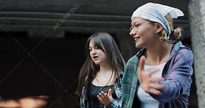 Young teenagers with a passion for street dance. Athletic girls in colorful loose clothing and crazy makeup choreography