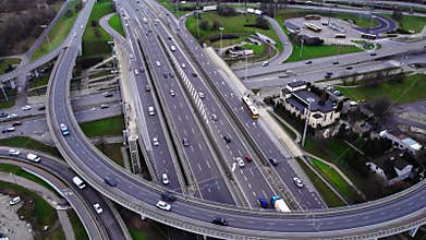Aerial drone top view of multilevel highway with bridges and ramps, and cars going