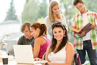 Teens studying in high-school library young pupils