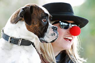 A Lovely Young Woman Laughing with her Boxer Dog