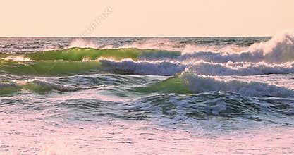 Sea sunrise and rolling big waves toward the sea shore and sandy beach
