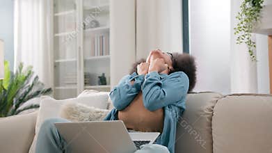 Happy girl winner shock surprise amaze wonder online laptop winning at home couch excited African American successful