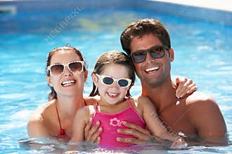 Family Having Fun In Swimming Pool