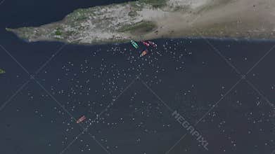 Aerial video of people feeding birds on a fishing boat along the Yamuna river in New Delhi, India.