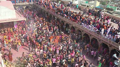 Aerial footage of people celebrating the holi color festival at Nandgaon Temple, Uttar Pradesh, India.