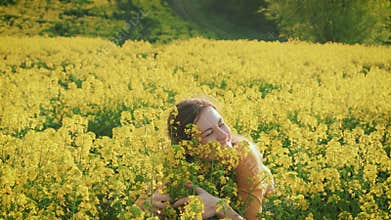 happy woman farmer with love embrace hugs her crop harvest rapeseed flowers