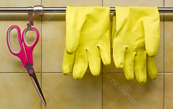 Rubber Gloves and Scissors Against Kitchen's Wall