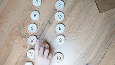 Teaching mathematics according to the Montessori method. Wooden tokens with numbers and signs. Comparison of numbers