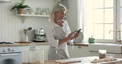 Happy chef blogger woman in apron baking in kitchen