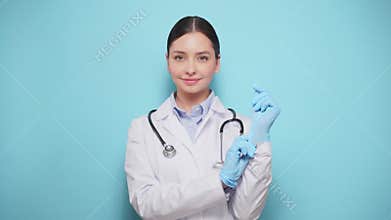 Female doctor puts on medical gloves