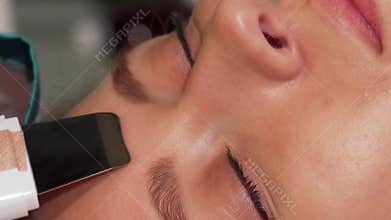 Young woman indulging in a revitalizing ultrasonic facial treatment at a beauty salon