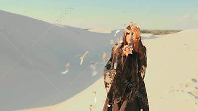 Beauty woman dancing in black dress. fashion model throws sprinkles gold glitter