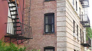 New York City building architecture, Manhattan. Residential house exterior. Red brick, fire escape.