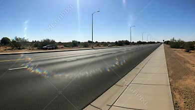 Empty sunlit road with visible heat waves in desert environment