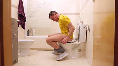 Man struggling with great constipation on toilet