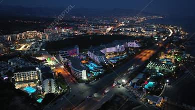 Stunning aerial sunset to night transition over Turkler in Alanya, Turkey. Alanya coastline,resorts,marina,hotels and city lights