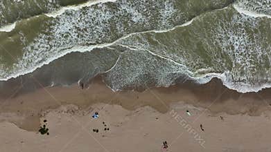 Deserted autumn beach. Calm sea waves rolling on empty sea beach at cold cloudy day