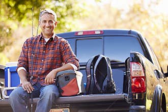 Portrait Of Man Sitting In Pick Up Truck On Camping Holiday