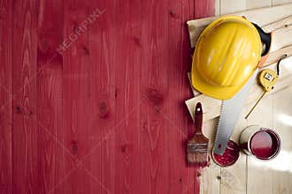 Red wood floor with a brush, paint, tools and helmet
