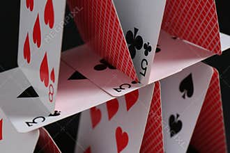 House of playing cards on black background, closeup