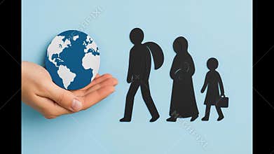Paper cutouts representing a refugee family walking towards a hand holding a small globe, symbolizing global migration, seeking