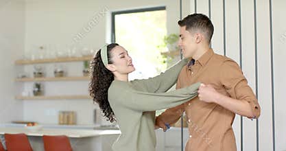Couple removing blindfold and guiding each other through dancing for intimacy in kitchen