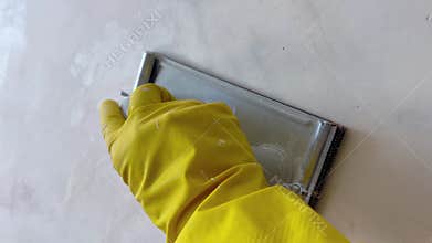 Worker sanding wall with hand sander