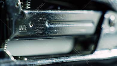 Extreme Macro View of a Metallic Stapler Pressing Down to Bind Office Documents