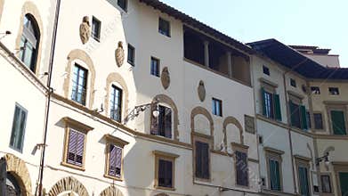 Historic building facade with arched windows and shutters, Florence Italy