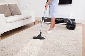 Maid cleaning carpet with vacuum cleaner