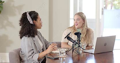 Diverse female hosts opening notebook typing laptop and adjusting microphone for studio recording